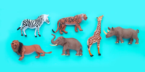 Plastic jungle animal toys on blue background.