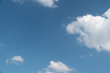 Naklejka na ściany i meble Blue sky with scattered white clouds