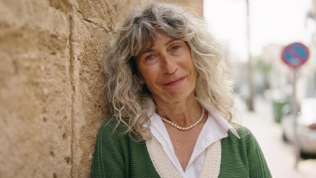 Middle age woman smiling confident standing at street