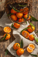 Tangerines falling out of the basket. Oranges, mandarins, clementines, citrus fruits) with leaves