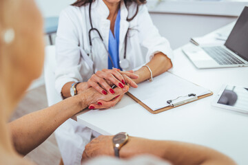 Female doctor holding hands of female patient at meeting as women health medical care concept express trust support empathy about miscarriage, help hope in cancer disease therapy, close up view