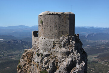 Ruins of the medieval Quéribus castle on top of a rocky mountain summit near Cucugnan village,...