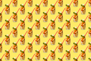 A repeating continuous pattern of a summer drink in a misted glass with slices of lemon and orange with ice on a yellow background