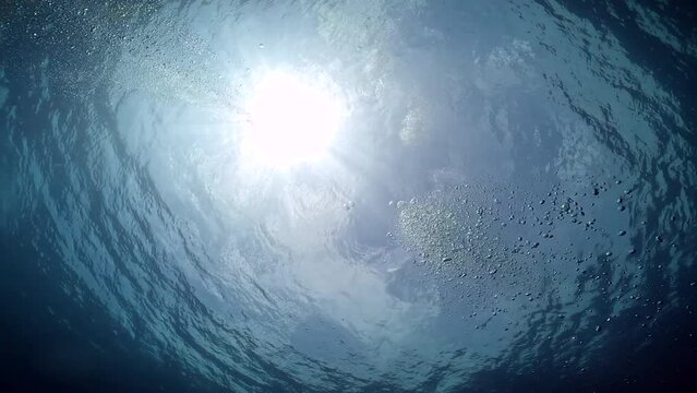 Under Water Film footage - Air bubbles rising to the surface with the sun light glaring down into the ocean  - Sail Rock island in Thailand