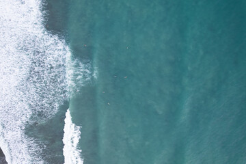 Amazing aerial view Top down of waves break on tropical sea Surfers with surfing boards Aerial drone view of sea waves on the beautiful ocean at Phuket Thailand