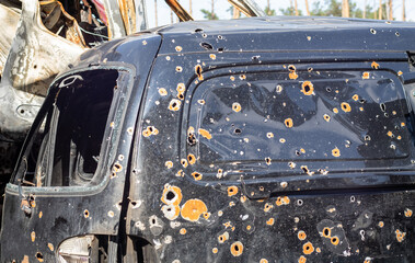 Shot, damaged cars during the war in Ukraine. The vehicle of civilians affected by the hands of the Russian military. Shrapnel and bullet holes in the body of the car. War of Russia against Ukraine.