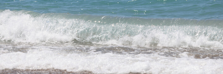 Fototapeta premium Blue sea waves with white foam on marine sand beach
