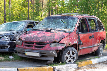 Obraz na płótnie Canvas Shot, damaged cars during the war in Ukraine. The vehicle of civilians affected by the hands of the Russian military. Shrapnel and bullet holes in the body of the car. War of Russia against Ukraine.