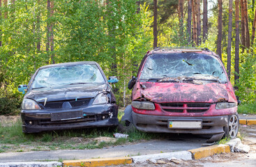 Obraz na płótnie Canvas A car destroyed by shrapnel from a rocket that exploded nearby. Irpensky automobile cemetery. Consequences of the invasion of the Russian army in Ukraine. Destroyed civilian vehicle.