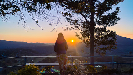 Young traveler woman with sunrise landscape scenery in the morning.