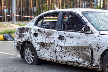 Shot, damaged cars during the war in Ukraine. The vehicle of civilians affected by the hands of the Russian military. Shrapnel and bullet holes in the body of the car. War of Russia against Ukraine.