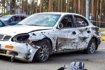 A car destroyed by shrapnel from a rocket that exploded nearby. Irpensky automobile cemetery. Consequences of the invasion of the Russian army in Ukraine. Destroyed civilian vehicle.