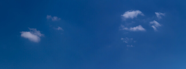 Naklejka na ściany i meble Blue sky with a few clouds background.