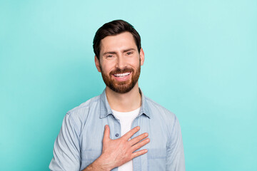 Photo of optimistic guy put hands chest feel grateful thankful charity isolated on cyan color...