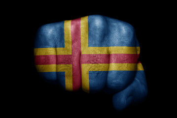 Flag of Aland painted on strong fist on black background