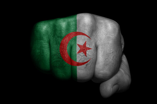 Flag of Algeria painted on strong fist on black background