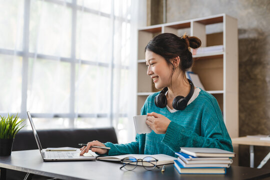 Young Attractive Asian Female Employee With Headphone Listen To Digital Online Course Development Program.