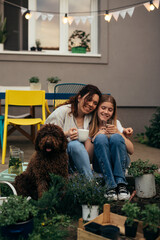 mother and daughter feeling relaxed. sitting on porch in their backyard