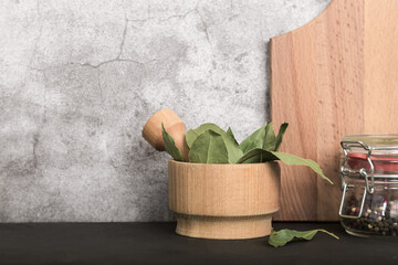 Spice bay leaf dried in a wooden mortar and pestle. Food kitchen background with copy space