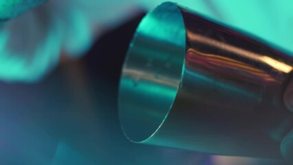 The bartender puts ice in the shaker in beautiful lighting. Bartender prepares cocktail with ice