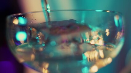 Bartender pours liquor into a glass in beautiful light
