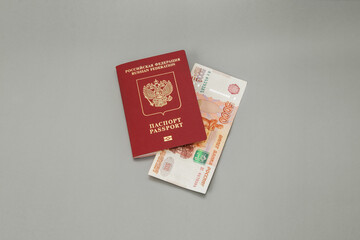 Russian foreign passport and 5000 Russian rubles cash on gray background. Travel abroad