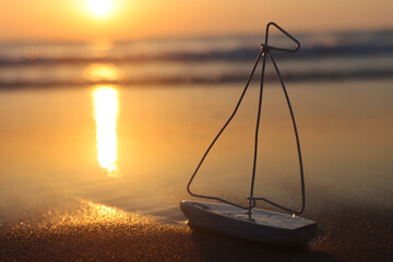 Image of small wooden boat on beach at sunset