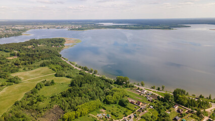 Obraz premium Aerial view of lake with sky reflection. Blue lake and green forest. Image for design. Space for text.