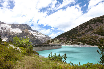 Fototapeta na wymiar Alps mountains beautiful landscape with turquoise water lake. High mountains nature and view on dam of Gelmer lake reservoir, sunny summer day.