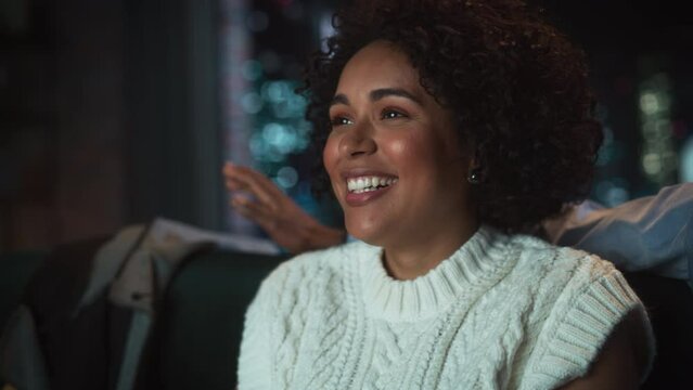 African American Happy Woman Enjoying Movie Streaming Service and Laughing Out Loud while Relaxing at the Sofa with her Boyfriend. Entertainment Concept