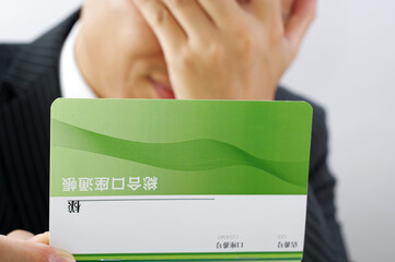 通帳を持つサラリーマン男性