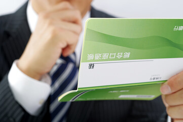 通帳を持つサラリーマン男性