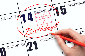 The hand circles the date on the calendar 14 December, draws a gift box and writes the text Birthday. Holiday.