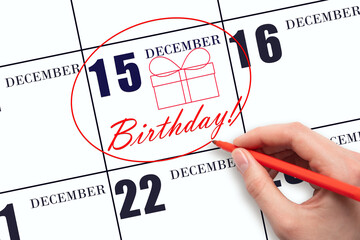 The hand circles the date on the calendar 15 December, draws a gift box and writes the text Birthday. Holiday.