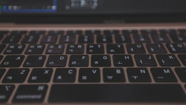 video moving from left to right of Apple Mac book air with M1 chipset. it shows its keyboard and a little part of its screen.