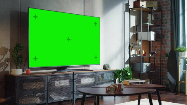 TV With Green Screen in Modern Living Room. Side view at Home with Chroma Key Placeholder on Monitor During the Day. Zoom Out Camera Shot