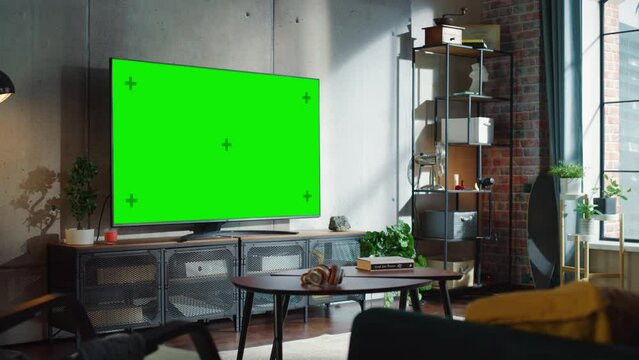 Modern Living Room Interior With Television Set with Green Screen Display, Sofa And Urban City View From The Window. Empty Apartments with Chroma Key Placeholder on Monitor