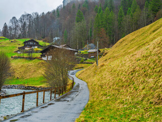 winding road alongside a river and traditional Swiss houses in Lauterbrunnen, Switzerland