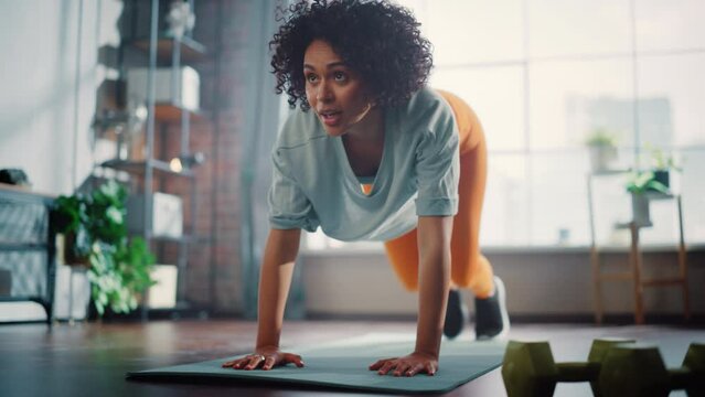 Strong Athletic Fit Black Woman Doing Cardio High Knees and Core Strengthening Exercises During Morning Workout at Home in Sunny Apartment. Fitness and Recreation Concept