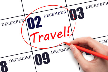 Hand drawing a red circle and writing the text TRAVEL on the calendar date 2 December. Travel planning.