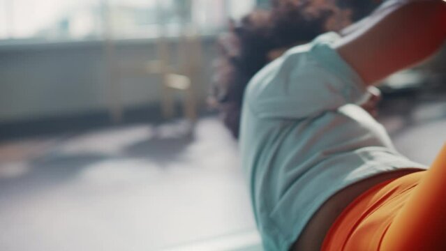 Black Athletic Fit Female Doing Crisscross Crunch Exercises at Home in Her Sunny Living Room. Woman Doing Workout Fitness Abdominal Exercises. Cinematic Slow Motion Handheld Shot