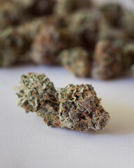 Dried and trimmed cannabis buds. Green marijuana buds with light natural background