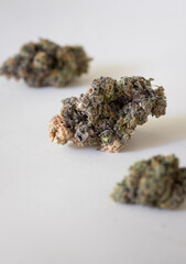 Dried and trimmed cannabis buds. Green marijuana buds with light natural background
