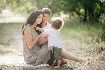 Happy young woman with children on wheat summer field. Happy motherhood.