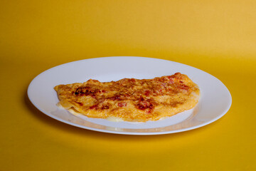 Omelete ovo frito em um prato branco com fundo amarelo isolado