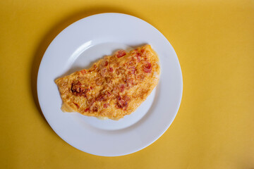 Omelete ovo frito em um prato branco com fundo amarelo isolado
