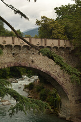 Fototapeta na wymiar Old stone bridge over the river Passer in Meran, South Tirol, Italy