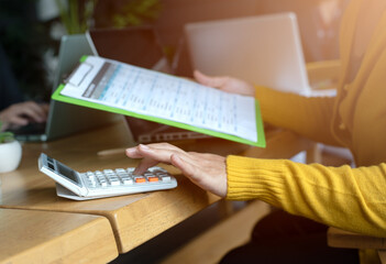 Asian office woman checking all equipments and paper report on the desk before start working of the day in the modern office room.