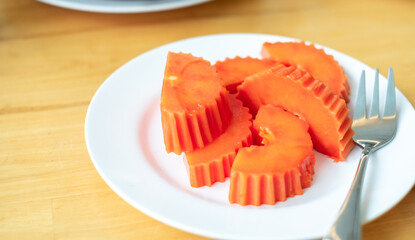 Ripe of Papaya slice and fork on white dish on dining table, breakfast