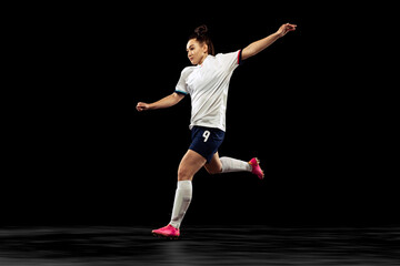 One caucasian energetic woman, soccer, football player in motion isolated on dark background. Sport, action, competitions, games and fitness concept